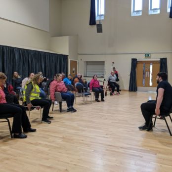 A group of people doing a seated exercise class