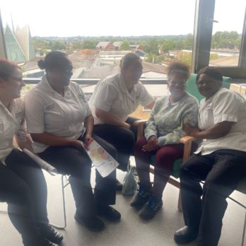 GOLD member sitting with four nurses