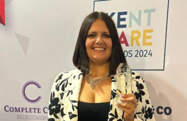 Vicki holding her award and smiling