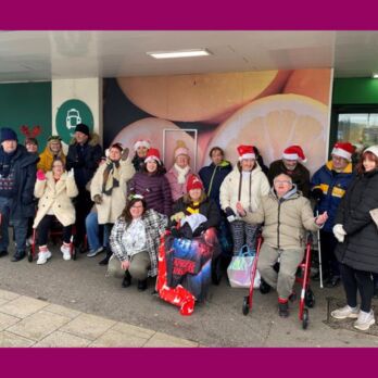 Herne Bay Hub carol singers standing outside Morissons looking festive with Santa hats and Christmas jumpers