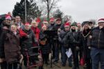 Group of festive carol singers standing outside